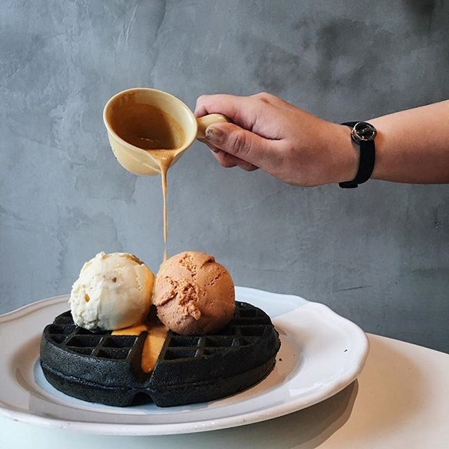 Charcoal waffle with salted egg yolk sauce topped with honey scotch & thai red tea ice cream.