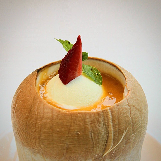 Vanilla ice cream floating in mango juice and sago served in a fresh coconut.