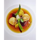 Oxtail consommé with scallops, beet, leeks, and black truffle.