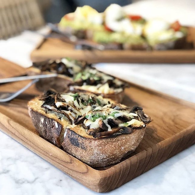 Open-face toast with roasted mushroom, creme fraiche and melted cheese.