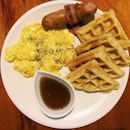 Waffle breakfast – waffle with pork sausage, bacon, scrambled eggs & maple syrup.