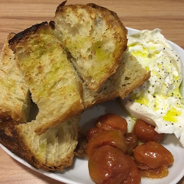 Burrata with bread drizzled with olive oil.