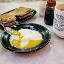 Super light lunch of two half boiled eggs, roti kosong (plain toast) and teh c kosong (milk tea without sugar).