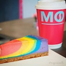 🍬 Paddlepop Rainbow Cheesecake | Caramel Macchiato 🍬Brighten up your day with this colourful slice of cake and @mocafesg’s Caramel Macchiato (S$5.90), which is made using quality coffee beans from @medanocoffee and served in a cheery neon pink cup.