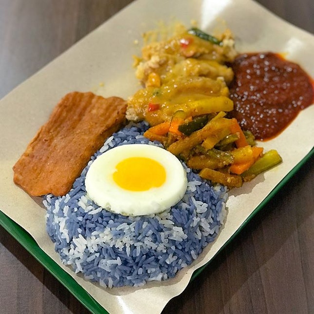 Nasi lemak with butterfly pea rice (Salted egg chicken, otah, fried egg, achar) [$5.30].