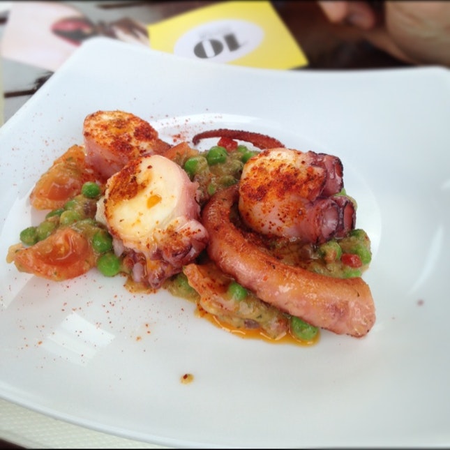 Spanish octopus "a la plancha" with peas, tomatoes and black olives
