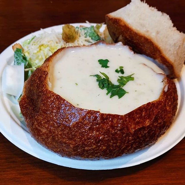 Clam chowder in sourdough bread bowl with Caesar salad.