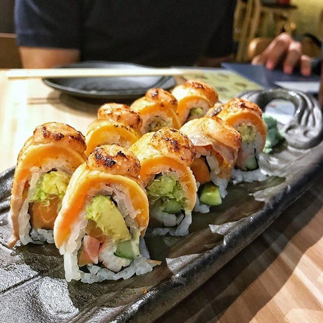 Salmon Aburi Roll; luscious grilled salmon wrapping another piece of salmon - sashimi, with avocado and crunchy cucumber, topped with a dollop of smoky mentaiko sauce.