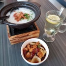Rice porridge with kung pao chicken and honey lemon water.