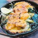 Oyster baked with cheese and on hot plate.