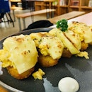 Scrambled eggs and cheese over potato nuggets.
